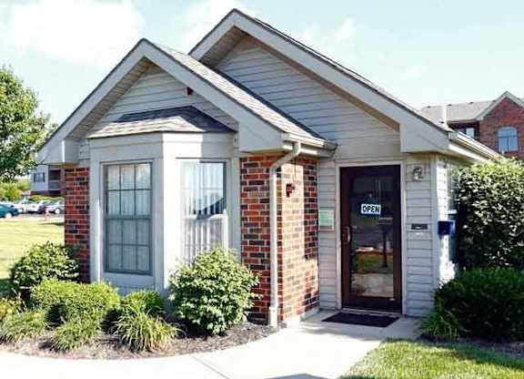 A small building with a glass door and a sign that says "OPEN".