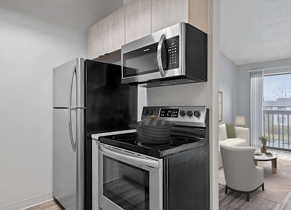 A modern kitchen with a black refrigerator, stove, and microwave. at The Reserve at Grand Valley Apartments, Milford