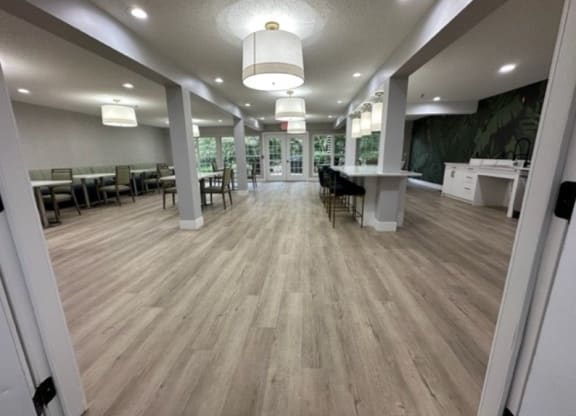 a large room with hardwood floors and white pillars