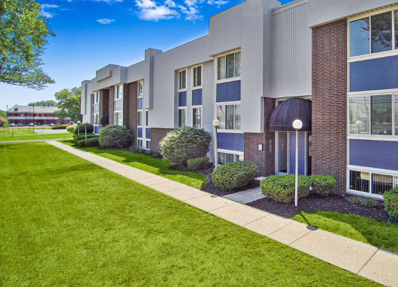 an apartment building with a sidewalk in front of it
