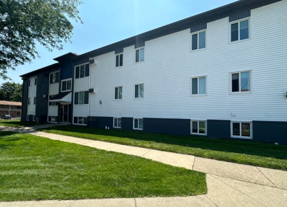 an exterior view of a white and blue apartment building