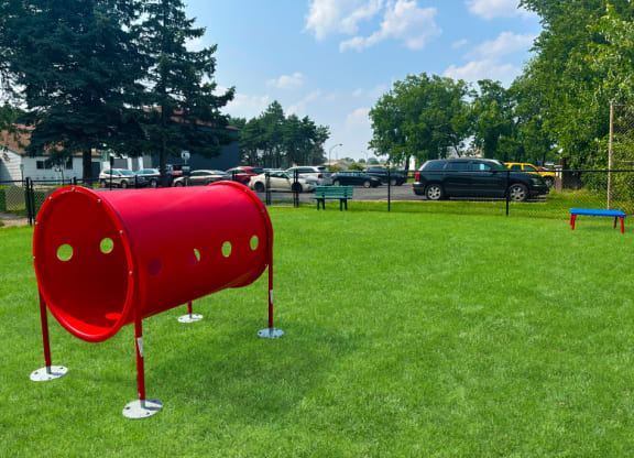 a red mailbox on a grassy field