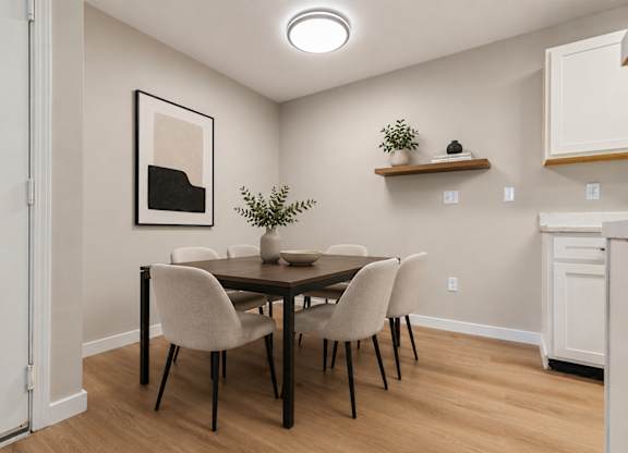 A dining room with a table and chairs.