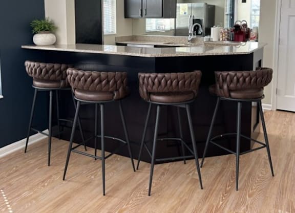 a kitchen with a counter top and some chairs