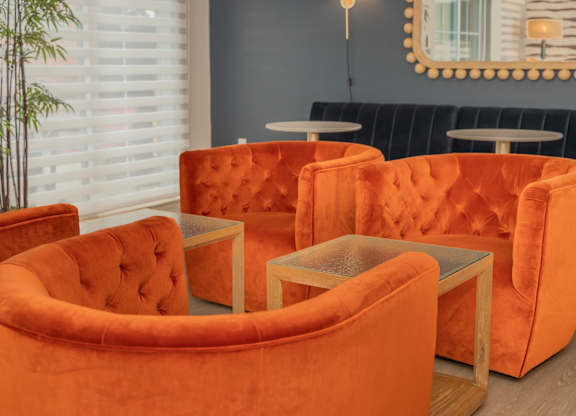 a group of orange chairs and tables in a room at Monmouth Row Apartments, Newport, 41071