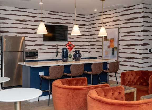 a living room with chairs and a table and a kitchen at Monmouth Row Apartments, Newport, Kentucky