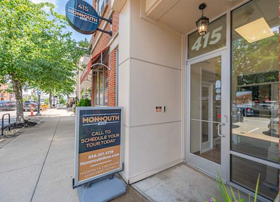 A Monmouth sign is on the sidewalk in front of a building.