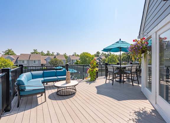 A patio with a blue couch and a table with chairs.