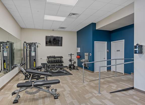A gym with a blue wall and a mirror.