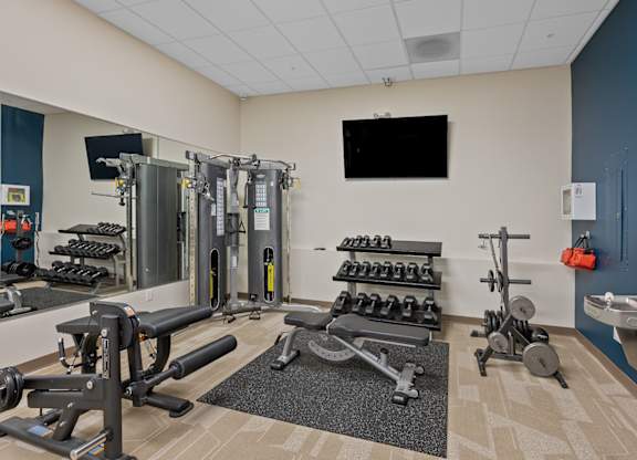 A gym with a variety of equipment including weights and machines.