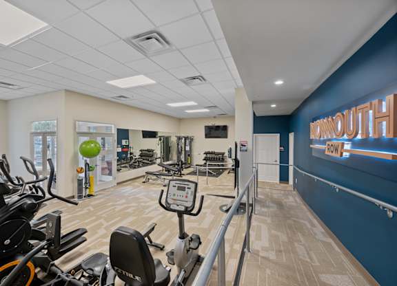 A gym with exercise equipment and a sign that says "MORNINGOUT".