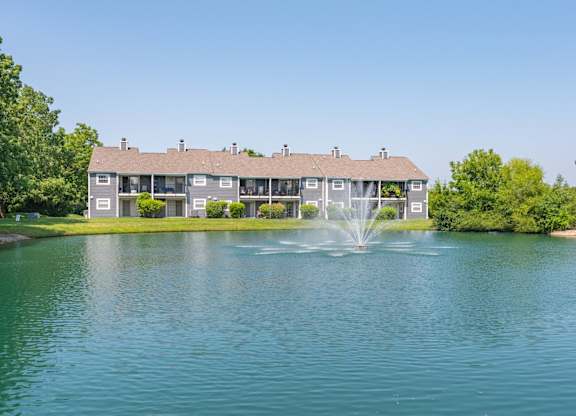 A house with a fountain in front of it.