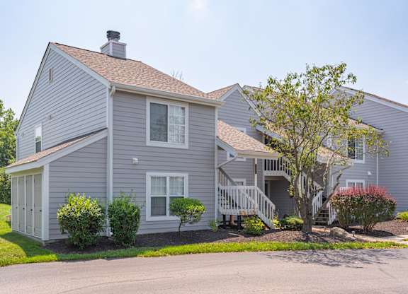 A house with a grey siding and a brown roof.