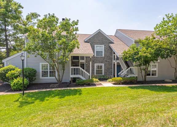 A house with a grey roof and a porch with a white railing.