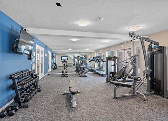 A gym with a variety of equipment including weights and machines.
