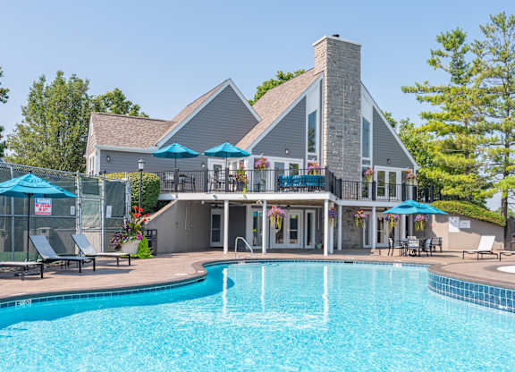 A large house with a pool in front.