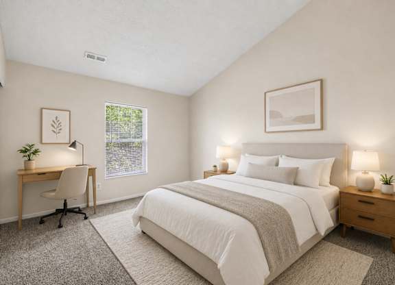 A bedroom with a large bed, a desk with a chair, and two lamps.