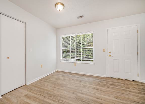 A room with a window and two doors.