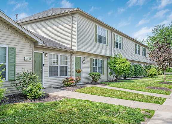 A row of houses with green bushes in front.