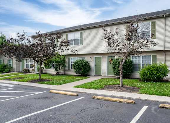 Apartment building with a parking lot in front.