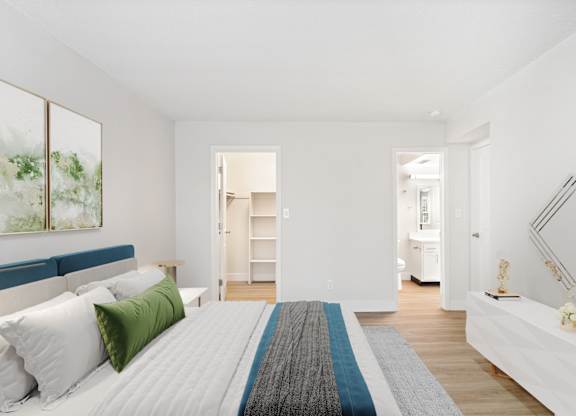 A bedroom with a large bed and a painting on the wall.
