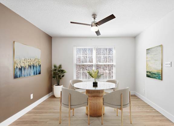 A dining room with a table and chairs.