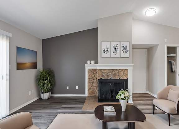 A living room with a fireplace and a painting on the wall.