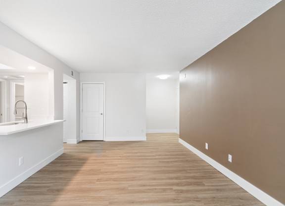 A room with a white sink and brown walls.