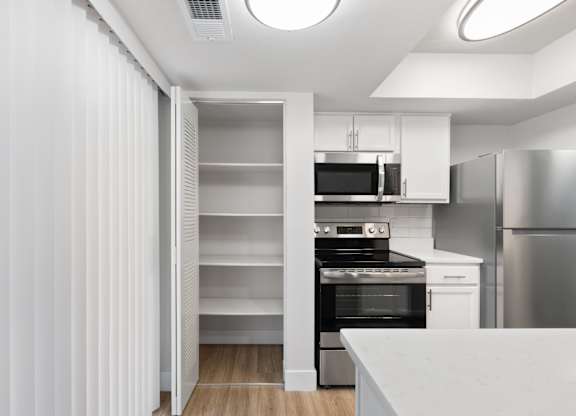 A modern kitchen with a refrigerator, oven, and microwave.