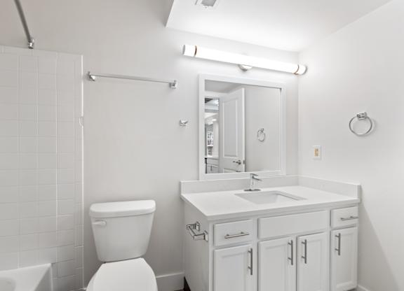 A white bathroom with a toilet, sink, and tub.