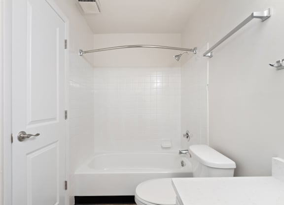 A white bathroom with a toilet, sink, and bathtub.