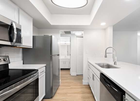 A modern kitchen with stainless steel appliances and white cabinetry.