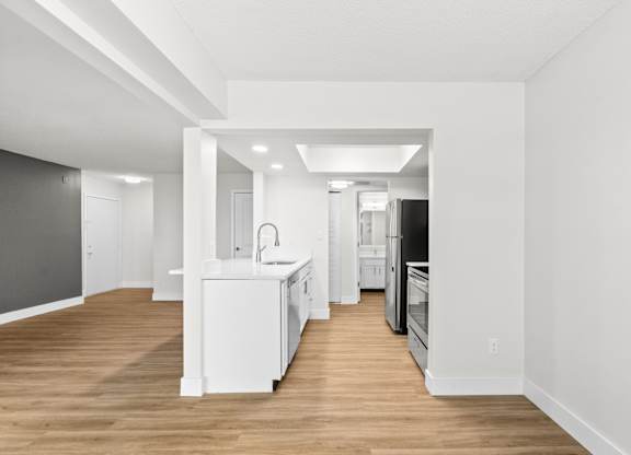 A kitchen with white appliances and a white island.