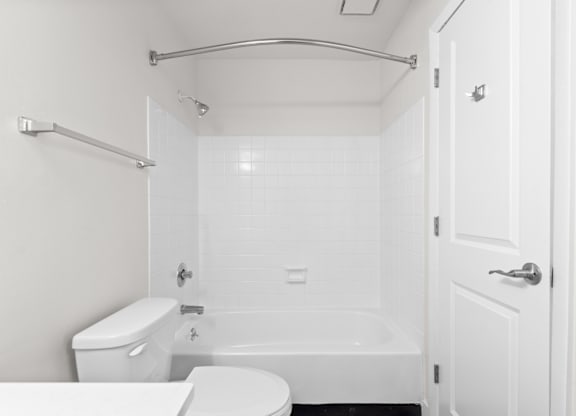 A white bathroom with a toilet, sink, and bathtub.