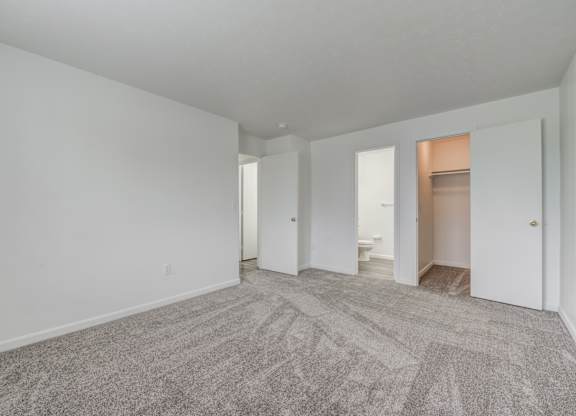 an empty living room with white walls and carpet