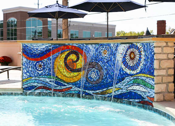 A pool with a mosaic tile wall.