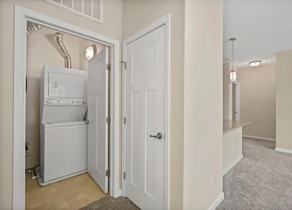 A white refrigerator is installed in a small room.