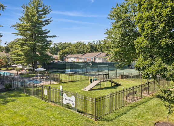 A black fence surrounds a green lawn with a sign that says Book Park.