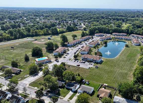A bird's eye view of a residential area with a swimming pool and a large building.