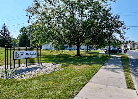 A sign that says Willow Lake stands in front of a grassy area.