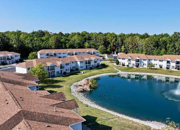 A large white building with a pool in front of it.