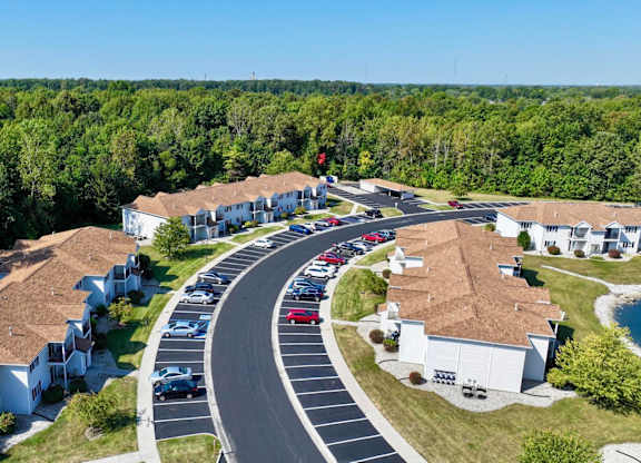 A road with cars and houses on both sides.