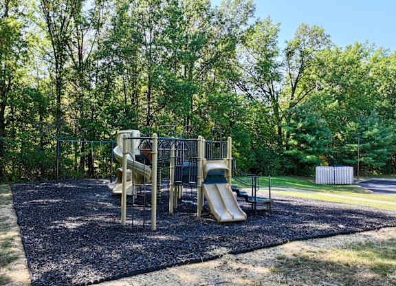 A playground with a slide and a climbing frame.