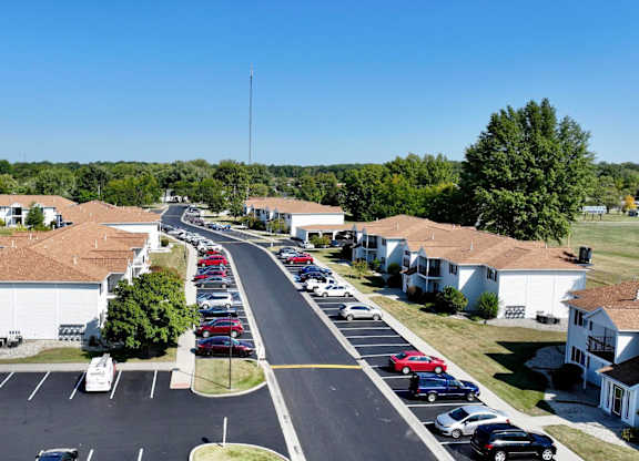 A parking lot with cars parked in rows in front of a building.