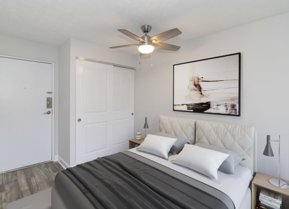 a bedroom with a bed and a ceiling fan