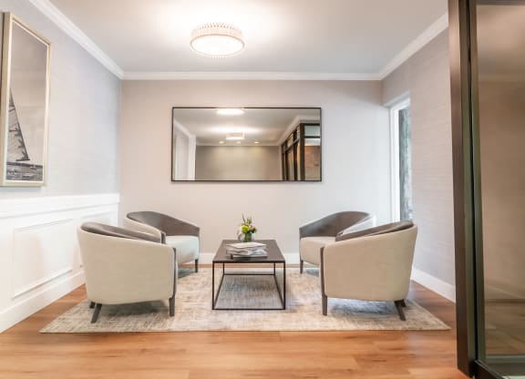 a living room with chairs and a coffee table and a mirror at Indian Creek Apartments*, Cincinnati, OH
