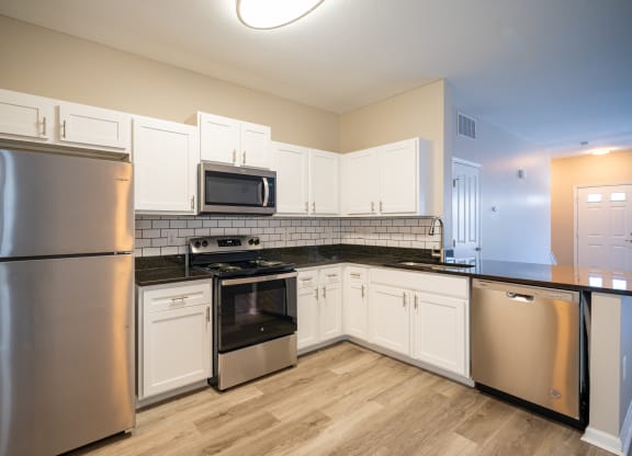 an empty kitchen with stainless steel appliances and white cabinets at Traditions at Slate Ridge, Reynoldsburg Ohio