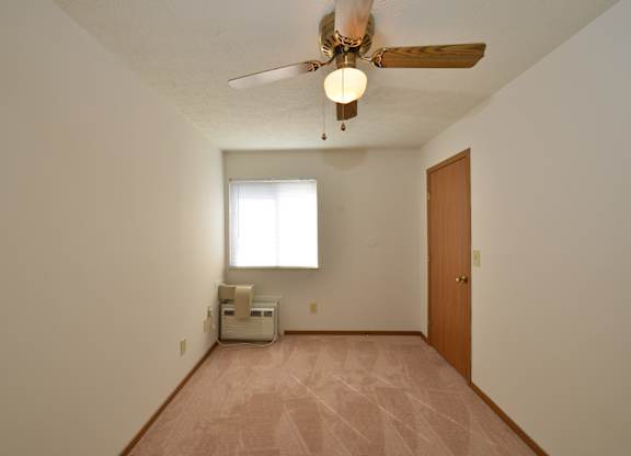 A room with a ceiling fan and a window.