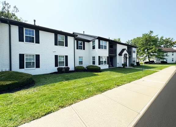A row of white houses with black shutters.