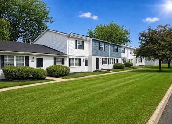 A row of houses with green lawns in front.